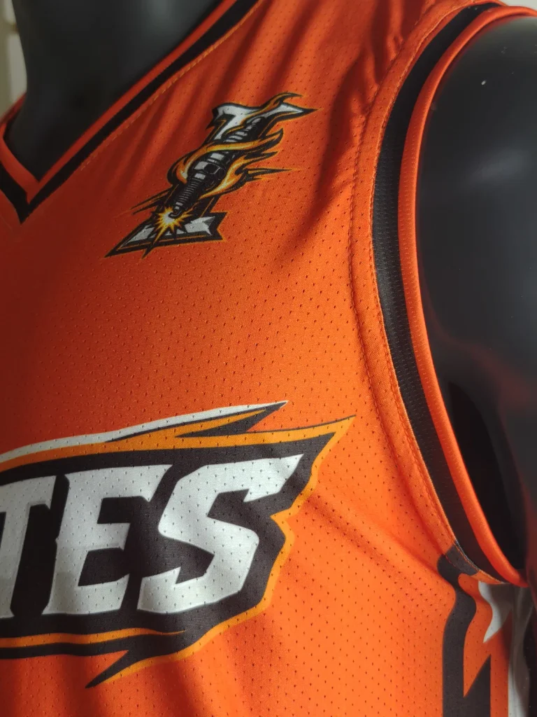 Close-up of the team emblem, orange fabric and black trim on the actual Ignites jersey